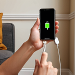 ** A hand carefully plugging a smartphone into a power outlet with a timer, showcasing mindful charging habits. Focus on creating a warm, inviting scene, possibly a cozy living room setting, subtly highlighting the importance of avoiding overnight charging to prolong battery life.

**